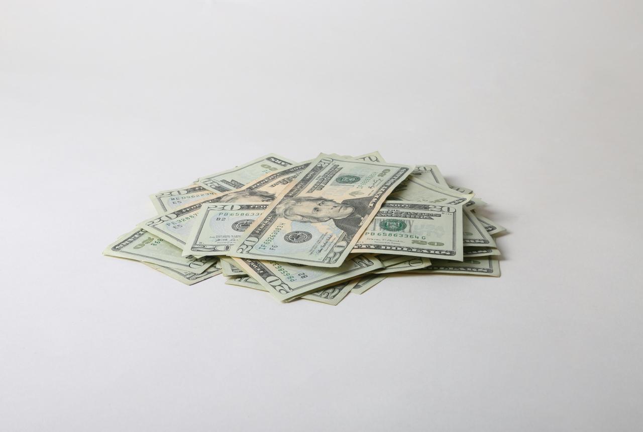 a pile of money sitting on top of a white table